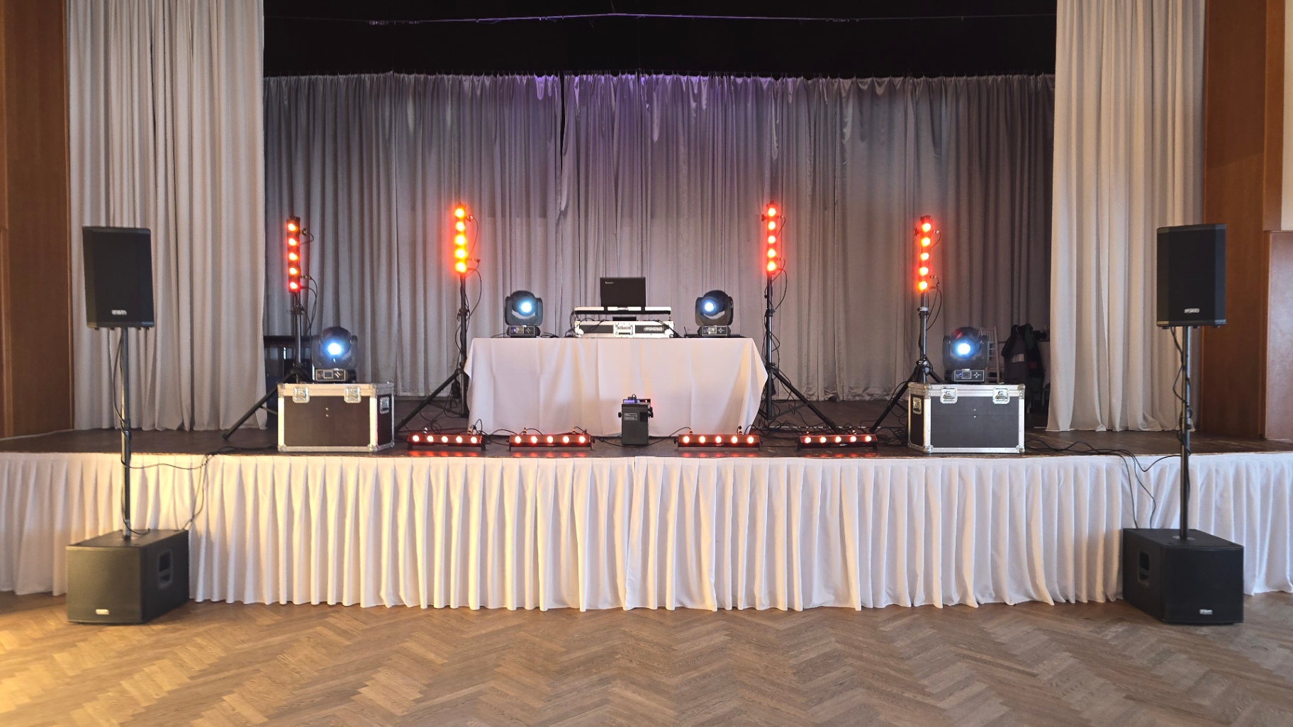 DJ stage s oranžovým osvetlením pred svadobnou hostinou